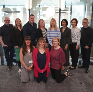 A photograph of a group of people stood together.