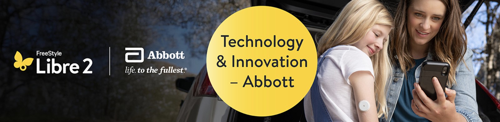 Libre 2 Abbott logo. A circle containing technology and innovation - Abbott and an image of a woman and a child looking at a phone.
