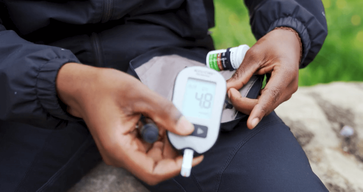 A boy is monitoring his glucose with a glucose monitor