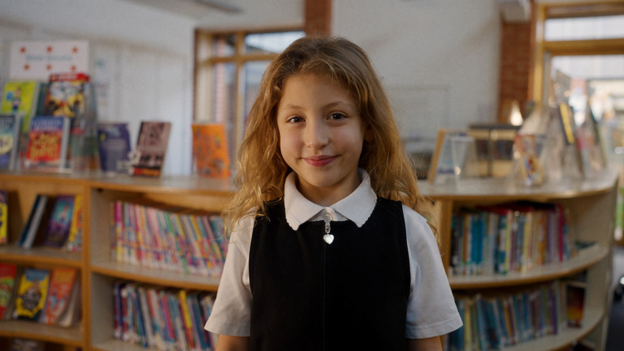 A young girl standing in a library