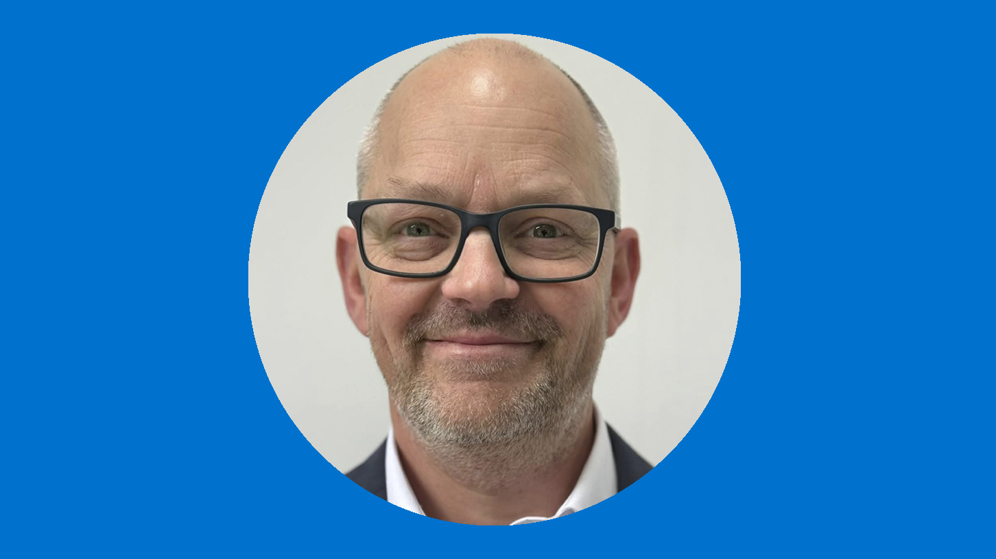 A man in glasses smiling at camera