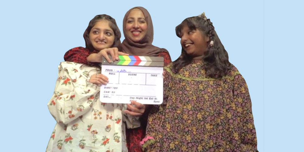 A mum and her two daughters stand together happy