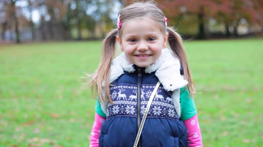 a happy young girl looks at the camera