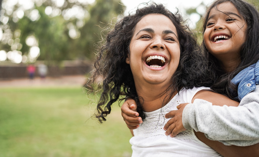 happy mum giving her child a piggy back
